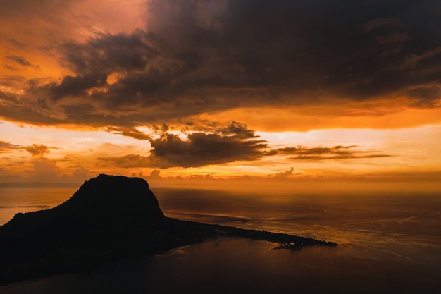 Vue aérienne avec l'océan à l'heure du coucher du soleil et la montagne du Morn à l'île Maurice.