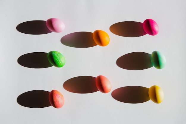 Vue aérienne des oeufs de Pâques avec des ombres sur fond blanc