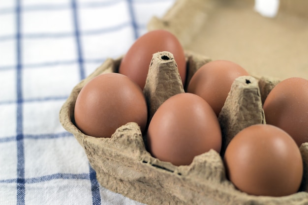 Vue aérienne d&#39;oeufs de poulet brun dans une boîte à oeufs ouverte. Frais