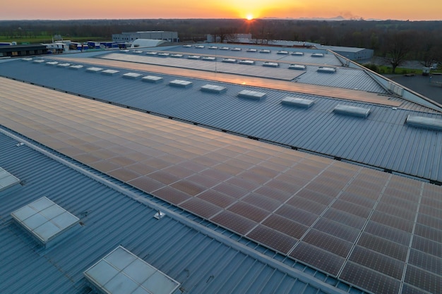 Vue aérienne de panneaux solaires photovoltaïques bleus montés sur le toit d'un bâtiment industriel pour produire de l'électricité écologique verte Production d'un concept d'énergie durable