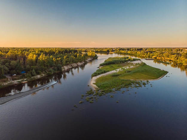 Vue aérienne par drone Le coude d'une large rivière parmi les vertes prairies