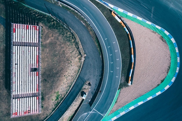 Vue aérienne par drone de haut en bas d'une piste de course avec des virages serrés et des épingles à cheveux