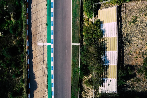 Vue aérienne par drone de haut en bas d'une piste de course avec des virages serrés et des épingles à cheveux