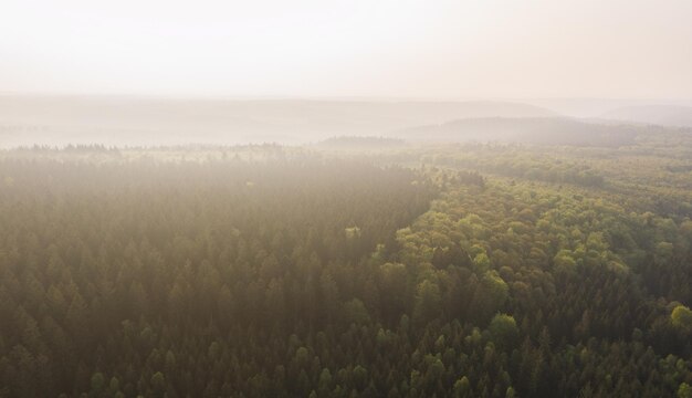 Vue aérienne par drone d'un paysage pittoresque avec des montagnes couvertes de nuages et de brouillard.