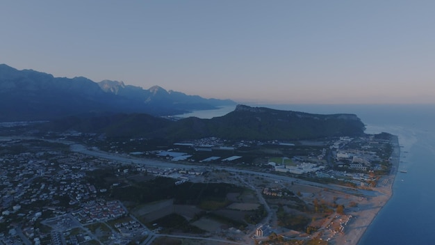 Vue aérienne par drone d'une ville touristique au bord de la mer Coucher de soleil sur fond de paysage de montagne Photographie