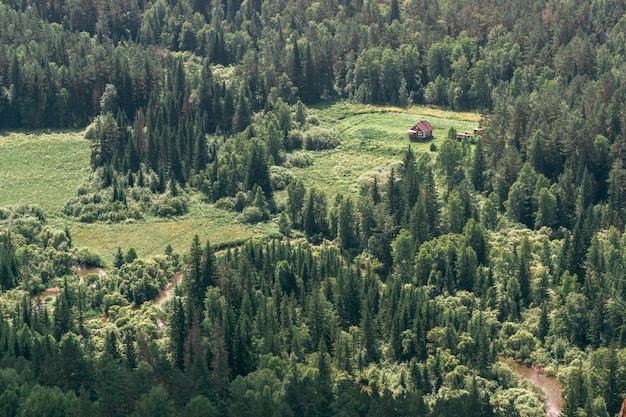 Vue aérienne d'une petite maison en bois dans une vallée verdoyante