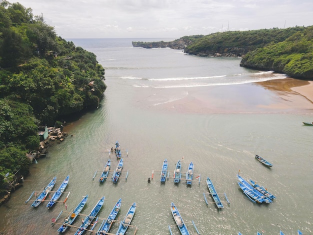 Vue aérienne de la plage de Baron à Yogyakarta Indonésie avec phare et bateaux traditionnels