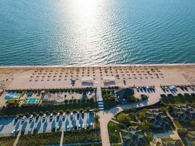 Vue aérienne de la plage avec parasols et mer turquoise à l'aube. Mer d'Azov, Schastlivtsevo