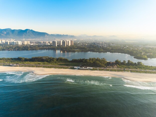 Vue aérienne de la plage de Reserva Lagune de Marapendi et circulation automobile sur l'avenue Lucio Costa Barra da Tijuca et Recreio à Rio de Janeiro Brésil Lever du soleil Journée ensoleillée Photo de drone Praia da Reserva