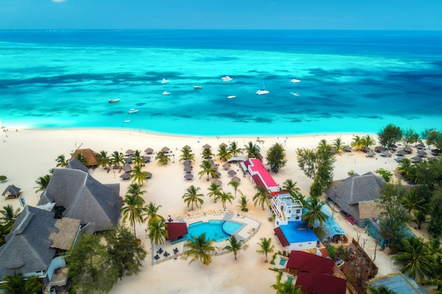 Vue Aérienne De La Plage De Sable Tropicale Avec Palmiers Et Parasols à Journée Ensoleillée