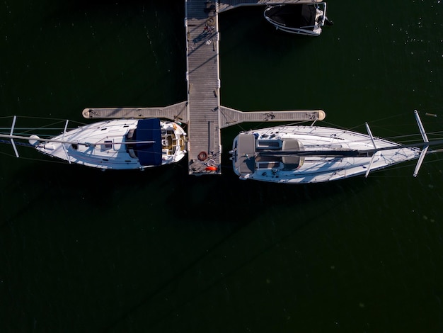 Vue aérienne d'un port de plaisance au bord de la mer orné d'élégants yachts créant une scène maritime pittoresque