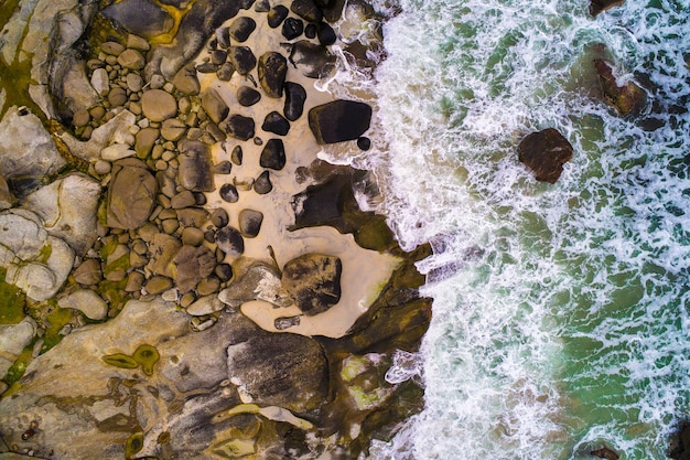 Vue aérienne en regardant les vagues de la mer frapper les rochers