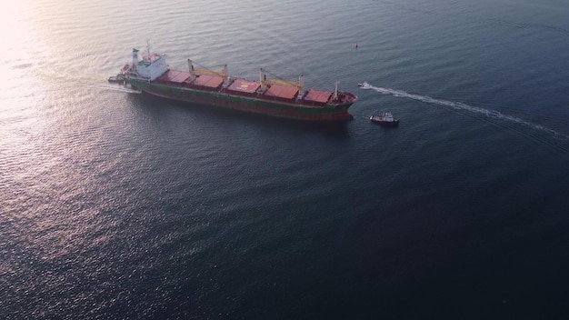 Vue aérienne d'un remorqueur aidant un gros vraquier cargo Grand navire escorté par un remorqueur
