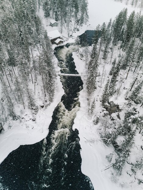 Vue aérienne de la rivière glacée qui traverse un magnifique paysage d'hiver enneigé dans le parc national d'Oulanka Ruka Finlande Photographie de drone