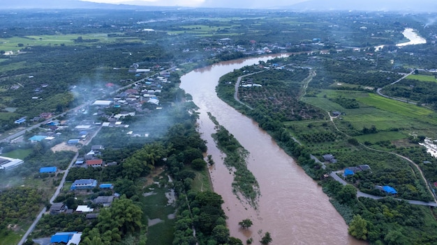 Vue aérienne de la rivière Ping à travers les rizières et les villages ruraux au coucher du soleil Vue des villages de Chiang Mai et de la rivières Ping depuis un drone