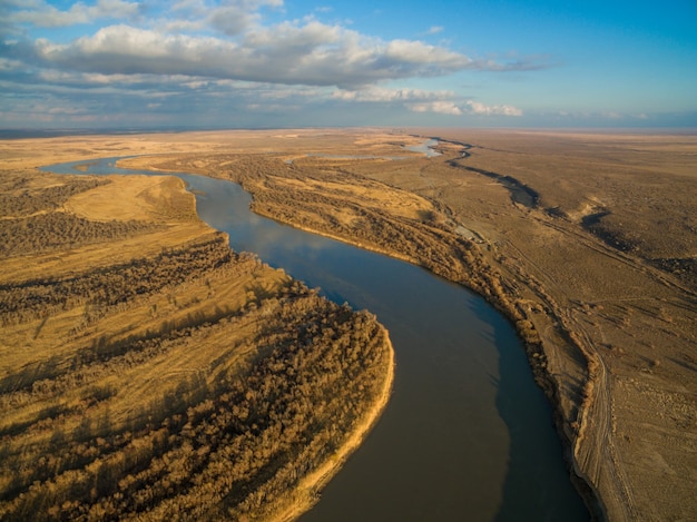 Vue aérienne de la rivière qui coule à travers la forêt dans la vallée alpine au Kazakhstan