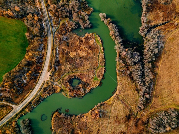 Photo vue aérienne de la rivière et de la route sinueuses dans la forêt d'automne ou d'automne aux couleurs dorées