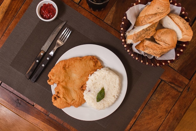 Vue aérienne de riz avec milanesa sur une assiette sur une table en bois