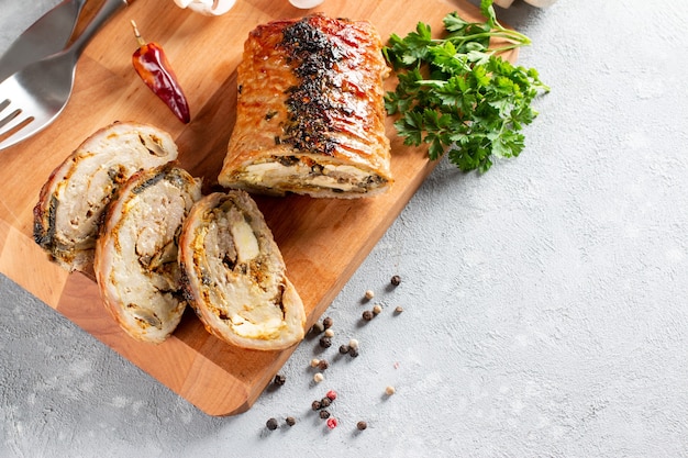 Vue aérienne de la roulade de porc rôti en tranches - Porchetta, délicieux rôti de porc de la tradition culinaire italienne sur une table en pierre