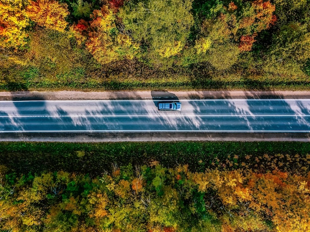 Vue aérienne de la route dans la belle forêt d'automne en Finlande rurale Beau paysage avec route rurale et arbres aux feuilles colorées