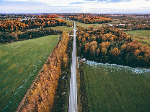 Vue aérienne de la route et de la forêt d'automne avec des arbres aux couleurs de l'automne