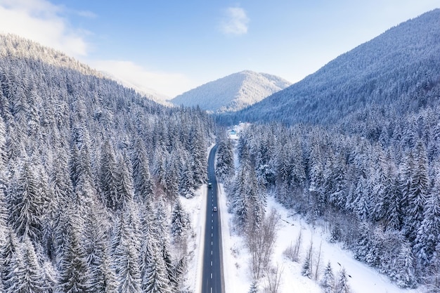 Vue aérienne sur la route et la forêt en hiver Paysage d'hiver naturel depuis l'air Forêt sous la neige en hiver Paysage depuis un drone