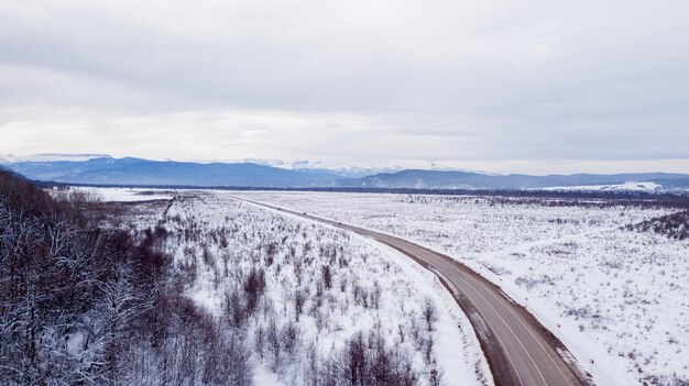 Vue aérienne sur la route rurale sinueuse en hiver