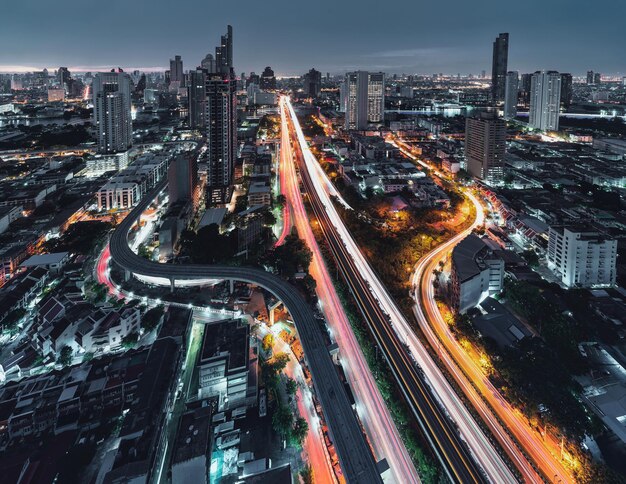 Vue aérienne de la route Trident à Sathorn, pont Taksin et trafic illuminé à l'aube à Bangkok, Thaïlande