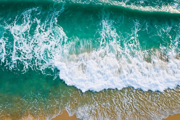 Vue aérienne spectaculaire d'une plage avec de l'eau de mer martelant le sable au rivage
