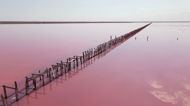 Vue aérienne de structures en bois pour recueillir le sel sur un lac rose