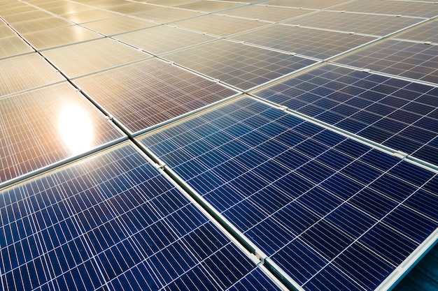 Vue aérienne de la surface des panneaux solaires photovoltaïques bleus montés sur le toit du bâtiment pour produire de l'électricité écologique propre. Production de concept d'énergie renouvelable.