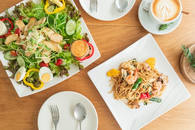 Vue aérienne de la table préparée par une salade et des spaghettis à manger.