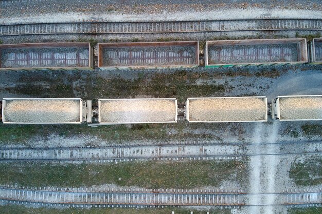 Vue aérienne d'un train de marchandises chargé de matériaux de pierre concassée à l'usine minière. Transport ferroviaire de minerai de calcaire broyé