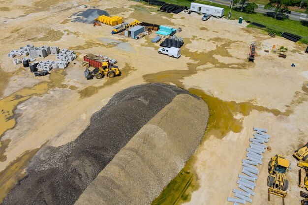 Photo vue aérienne des tuyaux du système d'égout de drainage empilés dans le sol pendant la préparation de la plomberie