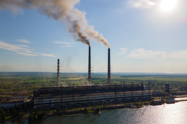 Vue aérienne des tuyaux hauts de la centrale au charbon avec une atmosphère polluante de cheminée noire. Production d'électricité avec concept de combustible fossile.