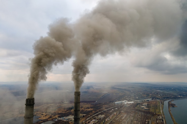 Photo vue aérienne des tuyaux hauts de la centrale au charbon avec de la fumée noire remontant l'atmosphère polluante.