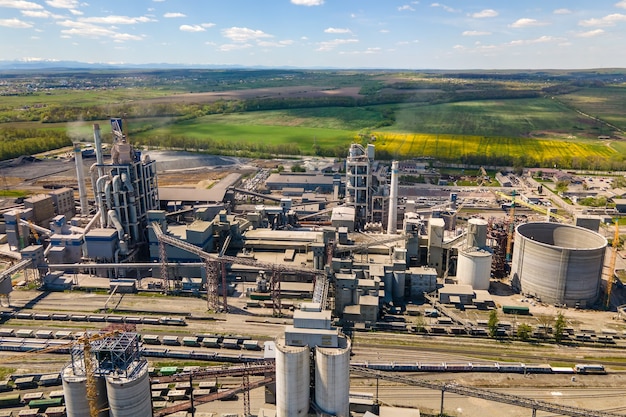 Vue aérienne de l'usine de ciment avec une structure en béton élevée et une grue à tour dans la zone de production industrielle. Concept de fabrication et d'industrie mondiale.