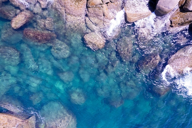 Vue aérienne des vagues déferlantes de la mer Vagues écumantes blanches sur les rochers du bord de mer Vue de dessus Côte rocheuse