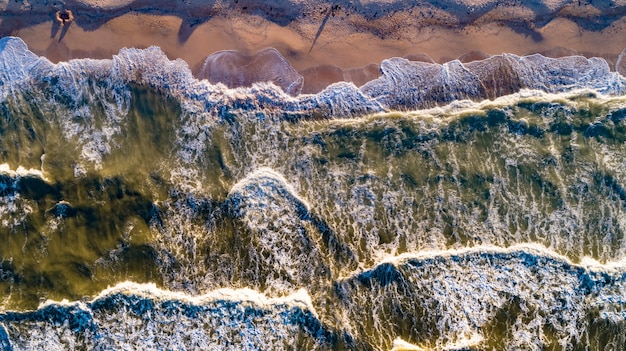 Vue aérienne des vagues sur la plage de sable. Vagues de la mer sur le drone de vue aérienne de la belle plage 4k tourné.