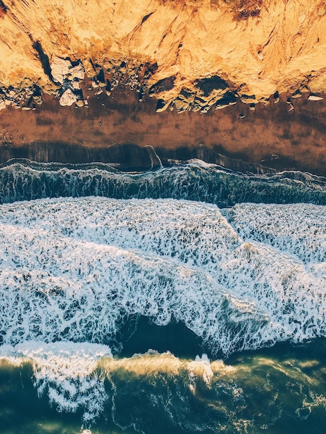 Vue aérienne des vagues qui se précipitent vers le rivage