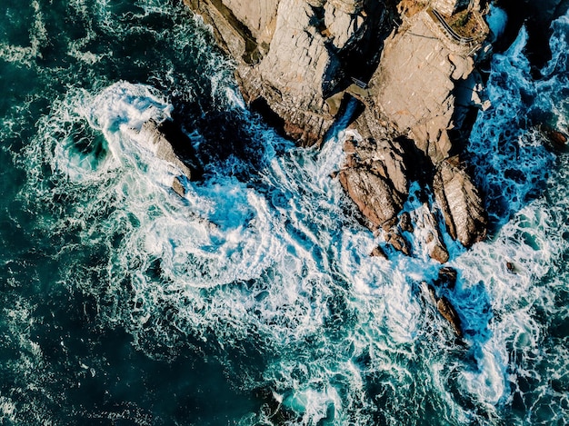 Vue aérienne des vagues et des rochers de l'océan Surface de la mer bleue et turquoise