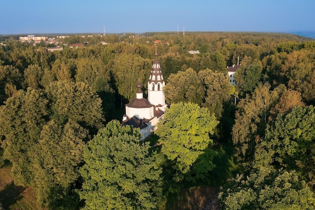 Vue aérienne de la vieille église orthodoxe russe blanche cachée dans la forêt dense Plyos Russie