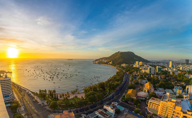 Vue aérienne de la ville de Vung Tau avec un beau coucher de soleil et tant de bateaux Vue panoramique côtière de Vung Tau d'en haut avec des vagues, des rues côtières, des cocotiers et la montagne Tao Phung au Vietnam