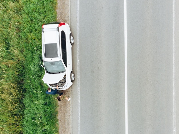 Vue aérienne d'une voiture cassée au bord de la route au milieu de nulle part