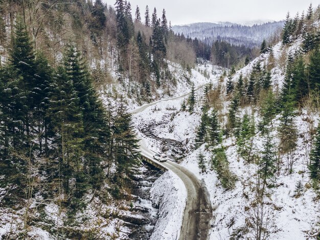 Vue Aérienne De La Voiture Se Déplaçant Par Canyon à L'espace De Copie D'hiver Enneigé