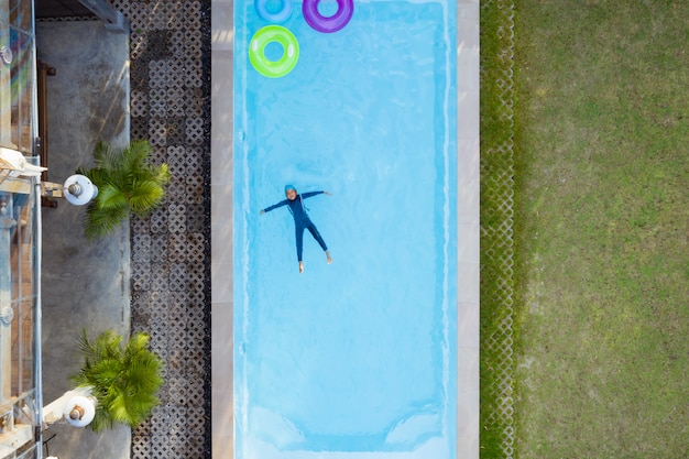 Vue aérienne ou vue de dessus de l'enfant nage dans la piscine