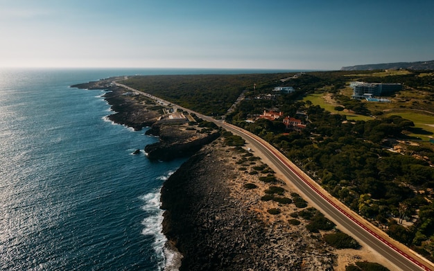 Vue aérienne vue de haut en bas d'une route droite et d'un littoral accidenté à la plage de Guincho Cascais Portugal