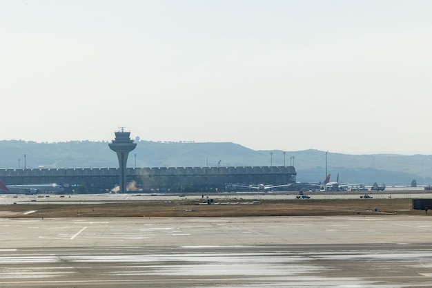 Vue de l'aéroport montrant un avion prêt au décollage, le bâtiment de l' aéroport et les installations aéroportuaires