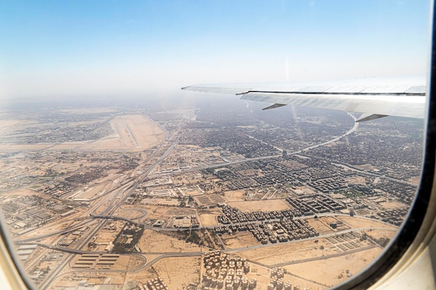 Vue de l'aile d'un avion au départ de l'aéroport et survolant la ville du Caire en Égypte