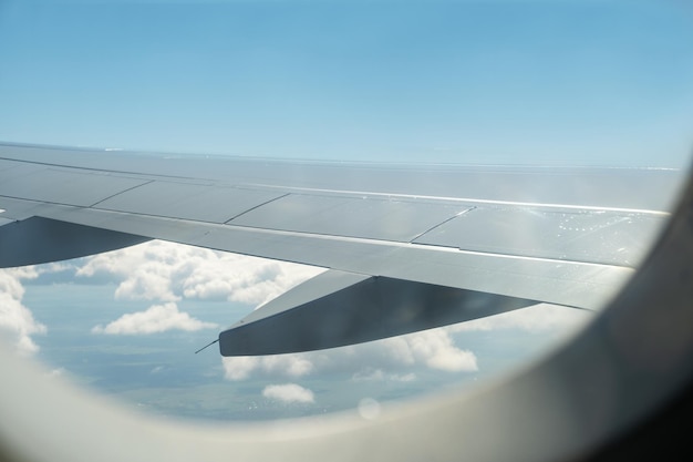 Vue de l'aile d'un avion et du ciel avec des nuages